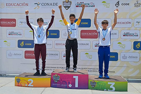 Eliam Antillón, estudiante y ciclista destacado, posa con sus dos medallas de oro obtenidas en los Nacionales CONADE 2024 en Jalisco. La promesa del ciclismo de Nuevo Casas Grandes sigue cosechando éxitos en su carrera deportiva.
