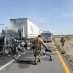 Personal de Protección Civil Ahumada y Bomberos trabajando para extinguir el incendio en la cabina de un tractocamión en la carretera Juárez-Ahumada.