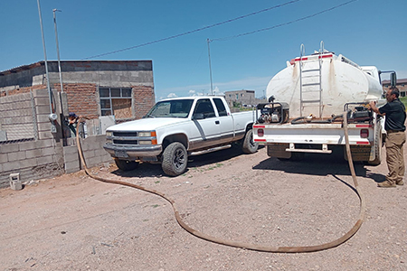 Bomberos de Nuevo Casas Grandes reparten agua en las colonias Miguel Ángel Escárcega y su ampliación, ante la escasez del servicio regular.